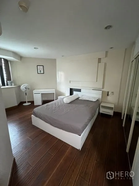 คอนโด ให้เช่า - ห้องนอนมุมห้อง พื้นไม้ เตียงสีขาว และตู้เสื้อผ้าบานกระจก