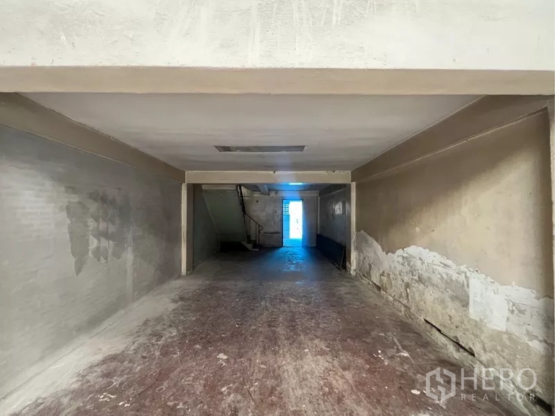 Shophouse for rent in Bangkok - Vacant ground-floor interior of the shophouse with deep open-plan layout, concrete floor and rear staircase.