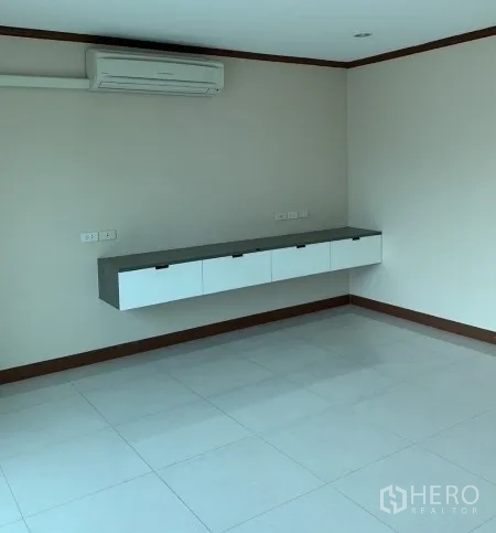 Home Office for rent - Corner office space with air conditioning and floating storage cabinet on glossy white tiles.