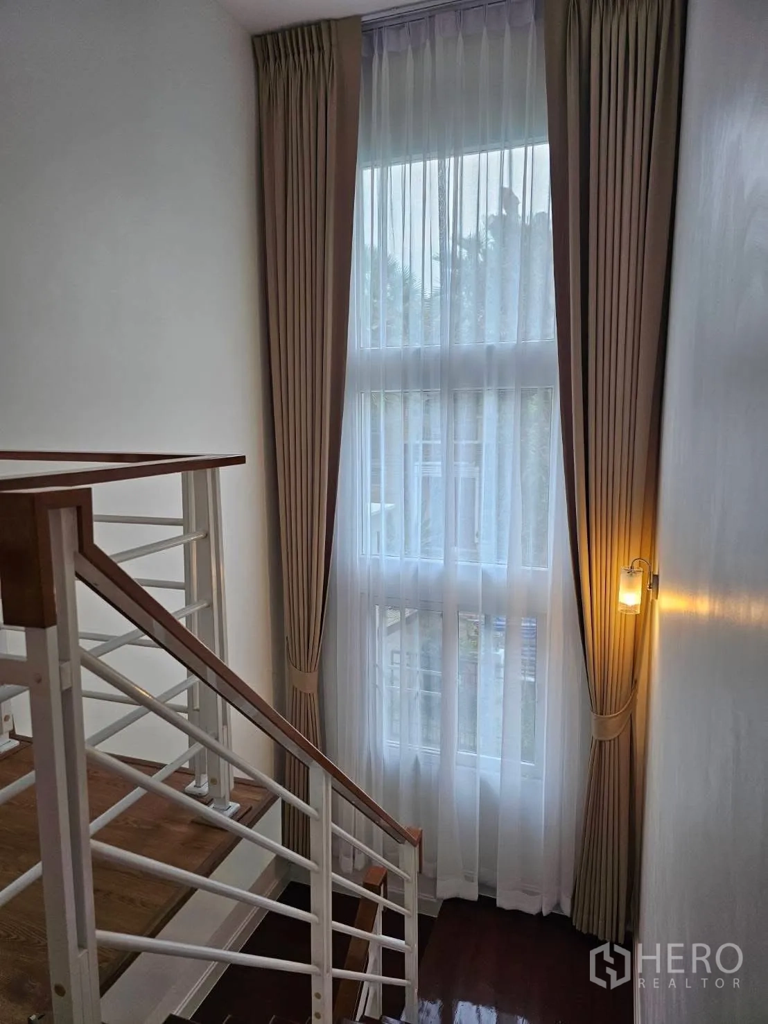 独栋房屋 for rent in Bang Phli, Samut Prakan - 楼梯平台，通高窗与窗帘。