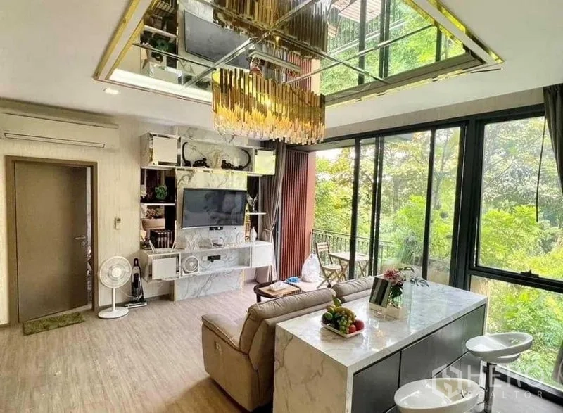 คอนโด ขายในWatthana, Bangkok - พื้นที่นั่งเล่นสว่าง เกาะครัวหินอ่อน โซฟา และประตูออกระเบียง มองเห็นต้นไม้