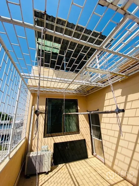 店屋 出租或出售在Suan Luang, Bangkok - 带金属网格顶的屋顶露台，配窗户与室外机。