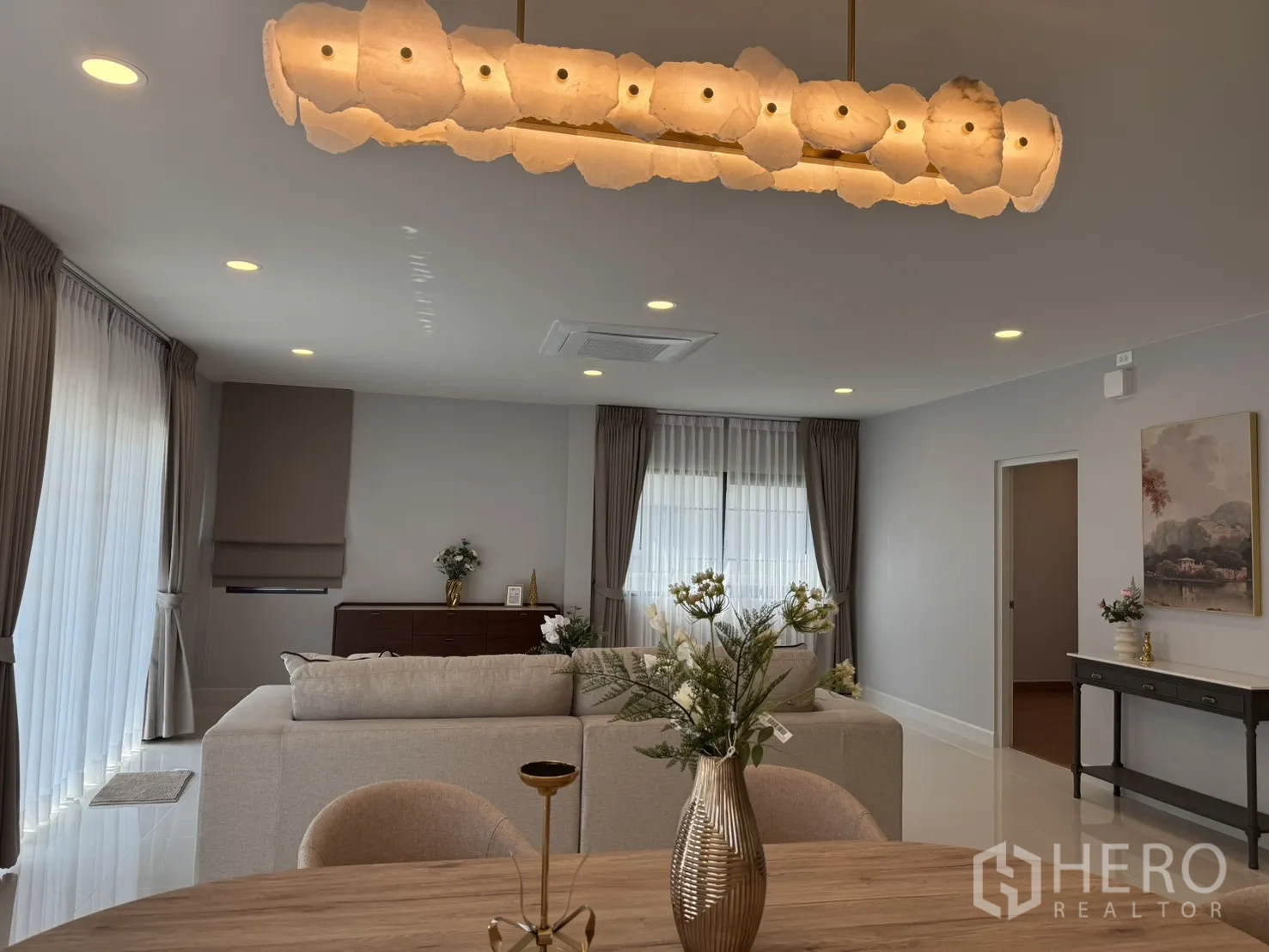 Detached House for rent in Bang Phli, Samut Prakan - Expansive living zone with statement chandelier over dining table and draped windows.