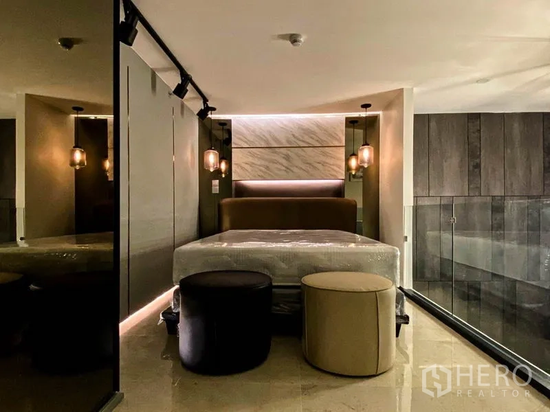 公寓 出租在Sathon, Bangkok - 温馨阁楼卧室，软包床头、吊灯与玻璃护栏。