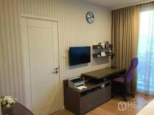 คอนโด ให้เช่าหรือขายในWatthana, Bangkok - มุมทำงานที่บ้านพร้อมโต๊ะ ทีวีติดผนัง ชั้นวางของ และผ้าม่านเปิดสู่ระเบียง