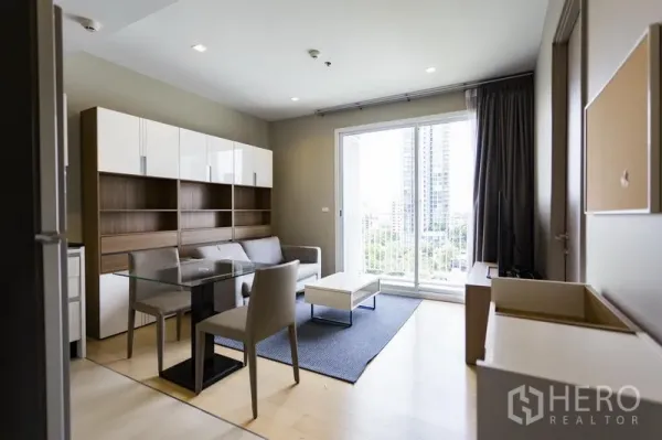 คอนโด ให้เช่าในWatthana, Bangkok - พื้นที่นั่งเล่นสว่างพร้อมโต๊ะรับประทานอาหารกระจกและประตูบานเลื่อนออกสู่ระเบียงวิวเมือง