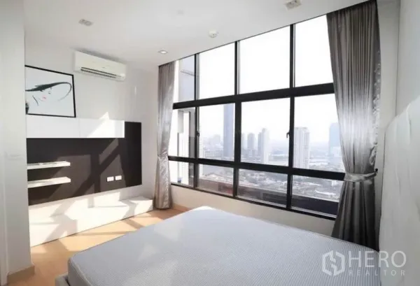 คอนโด ให้เช่าในKhlong San, Bangkok - ห้องนอนสว่างพร้อมหน้าต่างบานใหญ่และผ้าม่าน มุมมองสกายไลน์กรุงเทพฯ