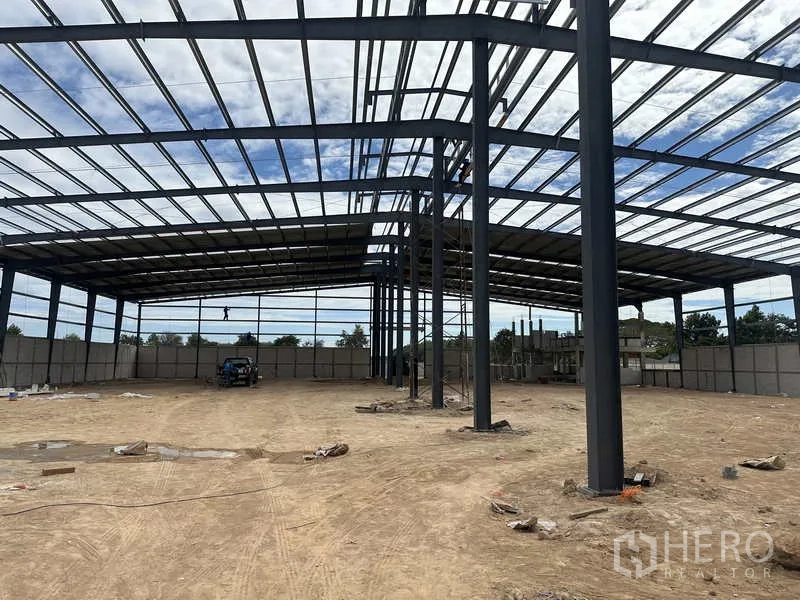 คลังสินค้า ให้เช่าหรือขายในNikhom Phatthana, Rayong - ภาพภายในโชว์เสาเหล็กช่วงกว้างและโครงหลังคาเหนือพื้นบดอัด