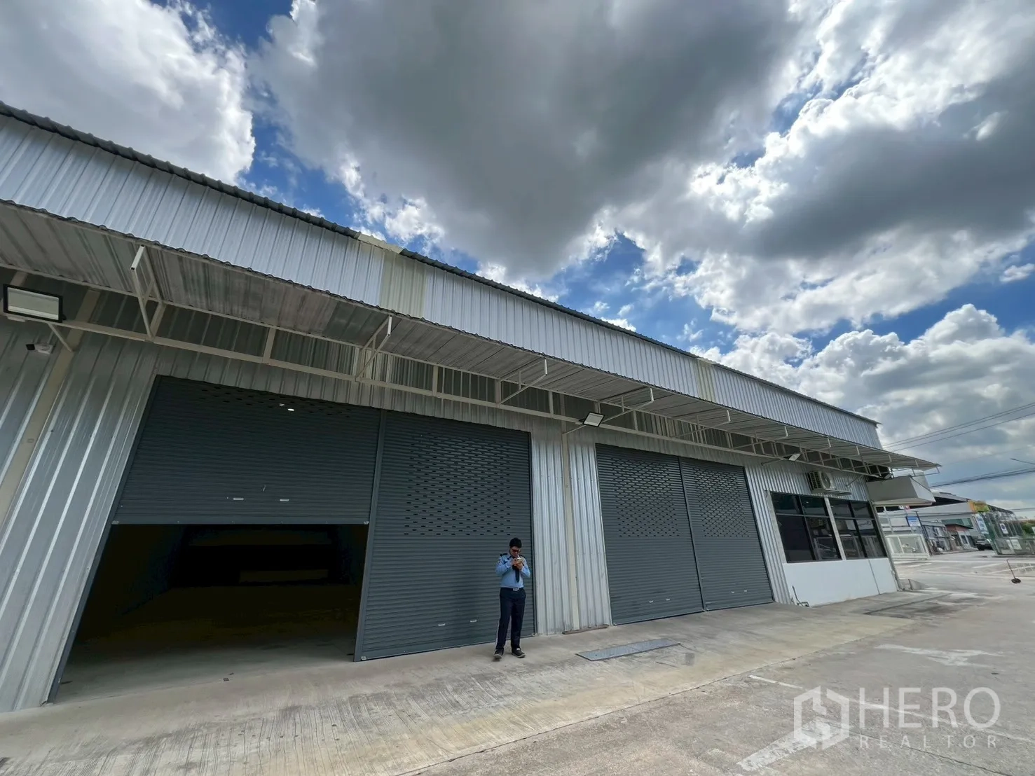 คลังสินค้า ให้เช่าในMin Buri, Bangkok - ด้านหน้าอาคารโกดัง ประตูม้วนหลายบาน พร้อมกันสาด