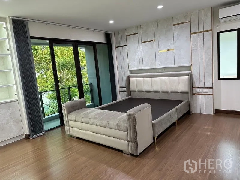บ้าน ขายในSaphan Sung, Bangkok - ห้องนอนใหญ่กว้าง เตียงบุผ้าและประตูเปิดสู่ระเบียง