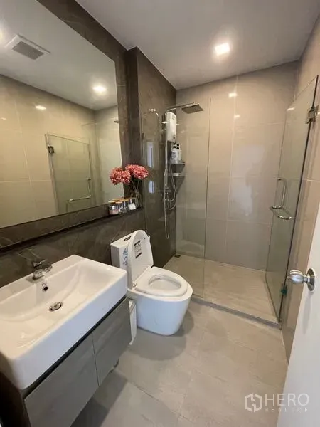 คอนโด ขาย - ห้องน้ำสไตล์โมเดิร์น กระจกบานใหญ่ ฝักบัวในตู้กระจก และตู้วางของใต้อ่าง