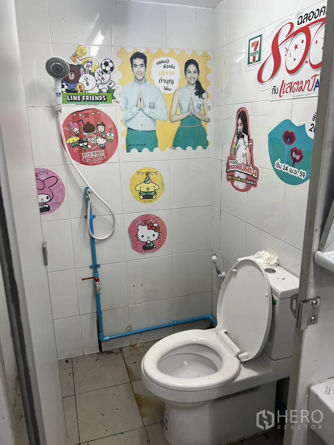 零售空间 出租在Suan Luang, Bangkok - 小型卫生间，坐便与手持花洒，瓷砖墙面带贴纸。