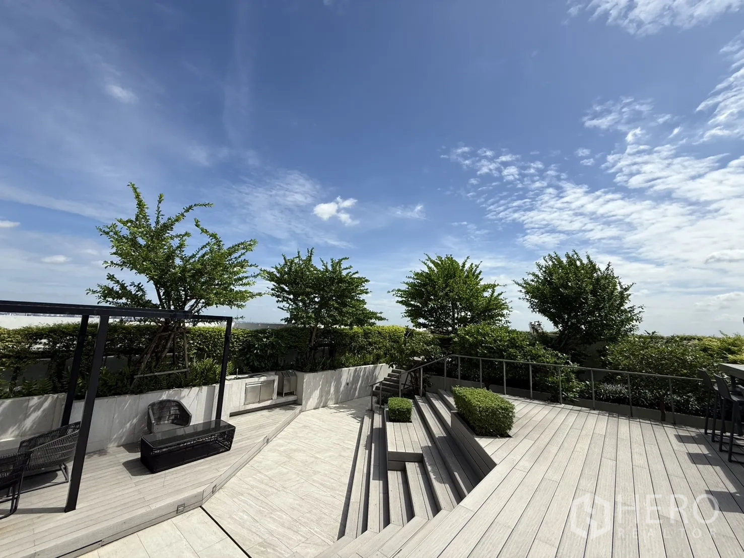 Condominium for sale in Chatuchak, Bangkok - Tiered outdoor deck surrounded by plants under open sky.