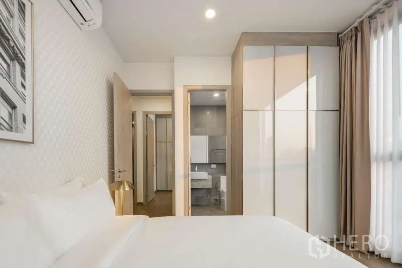 Condominium for rent - Master bedroom with built-in wardrobe and doorway to an en-suite bathroom.