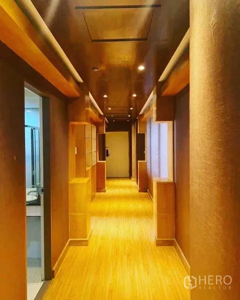 公寓 出租在Watthana, Bangkok - 公寓走廊以木质色调装饰，顶面筒灯照明。