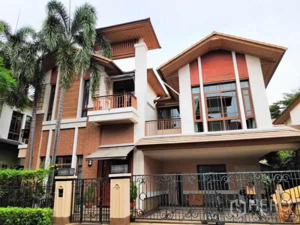 บ้าน ให้เช่าในWatthana, Bangkok - ด้านหน้าบ้านเดี่ยวสไตล์ร่วมสมัย 3 ชั้น มีระเบียง หน้าต่างบานใหญ่ และที่จอดรถมีรั้ว พร้อมต้นปาล์ม