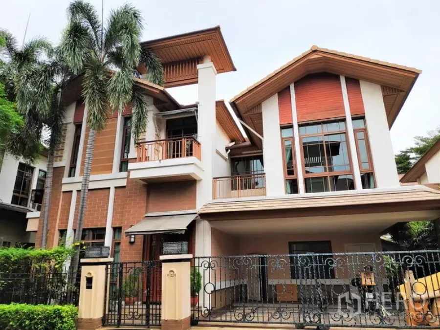 บ้าน ให้เช่าในWatthana, Bangkok - ด้านหน้าบ้านเดี่ยวสไตล์ร่วมสมัย 3 ชั้น มีระเบียง หน้าต่างบานใหญ่ และที่จอดรถมีรั้ว พร้อมต้นปาล์ม