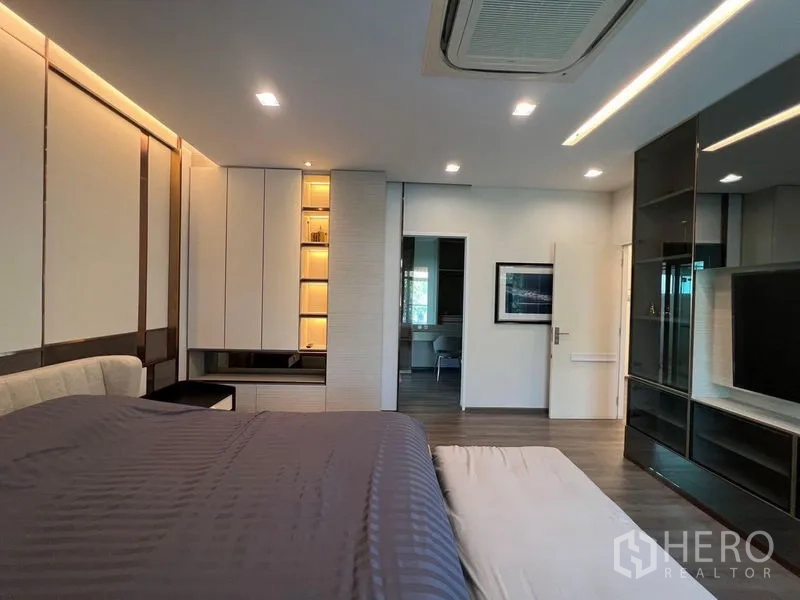 บ้าน ขาย - ห้องนอนหลักมุมมองตู้เสื้อผ้าบิลท์อิน ชั้นโชว์มีไฟ และผนังทีวีกระจก