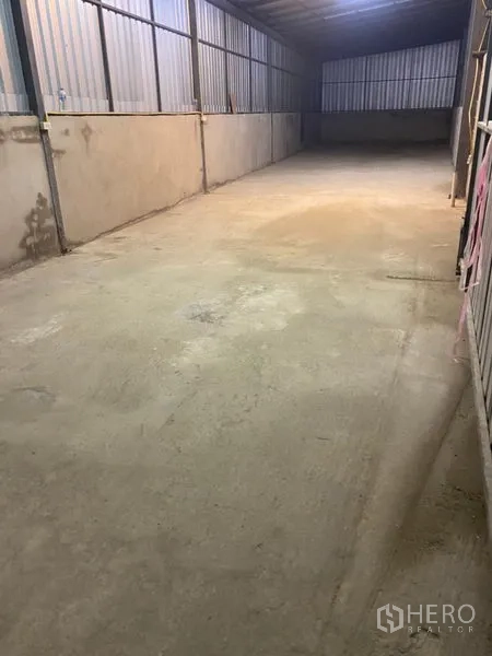 Warehouse for rent in Bang Kapi, Bangkok - Long storage bay with corrugated metal walls and level concrete flooring ideal for racking and loading.