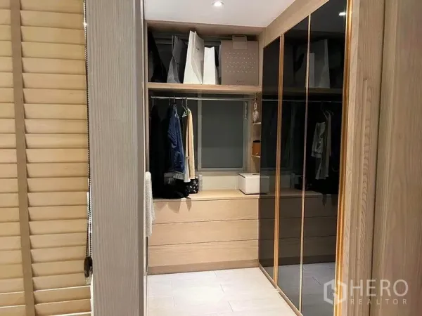 公寓 出售在Huai Khwang, Bangkok - 步入式衣帽间，木质柜体、镜面衣柜门、抽屉与小窗，配嵌灯照明。