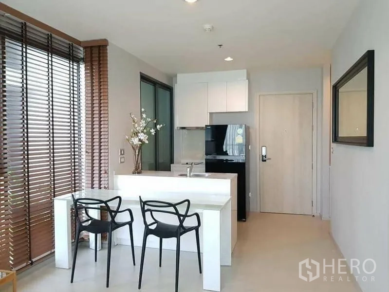 คอนโด ให้เช่าหรือขายในKhlong Toei, Bangkok - ครัวกะทัดรัด ตู้สีขาว ตู้เย็นสีดำ โต๊ะอาหารกระจก และประตูทางเข้า