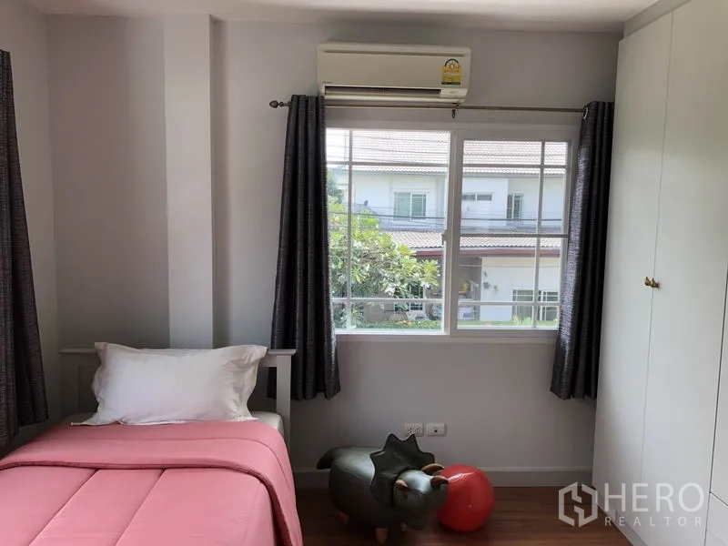 Detached House for rent or sale in Bang Kapi, Bangkok - Child’s bedroom with single bed, wardrobe and window overlooking neighboring homes.