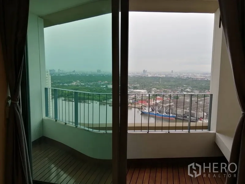 Condominium for sale in Yan Nawa, Bangkok - Covered balcony overlooking the Chao Phraya River and city skyline.
