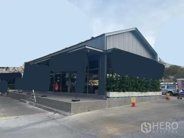 零售空间 出租在Khlong Toei, Bangkok - 独栋金属外墙零售建筑，玻璃门面、抬高门廊与金属人字顶。