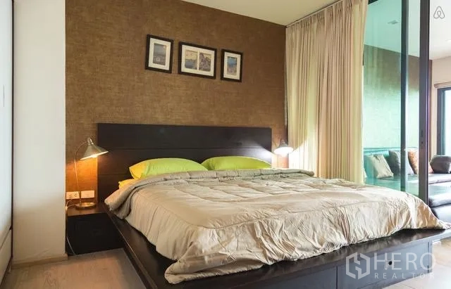 คอนโด ให้เช่าในKhlong Toei, Bangkok - ห้องนอนอบอุ่น มีเตียงขนาดใหญ่ โคมไฟข้างเตียง และประตูกระจกบานเลื่อน