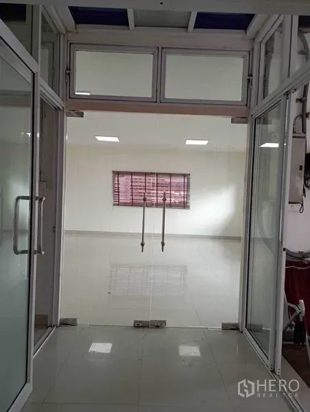 Office Space for rent in Khlong Toei, Bangkok - Entrance through double glass doors opening to a clean open-plan office with large window.