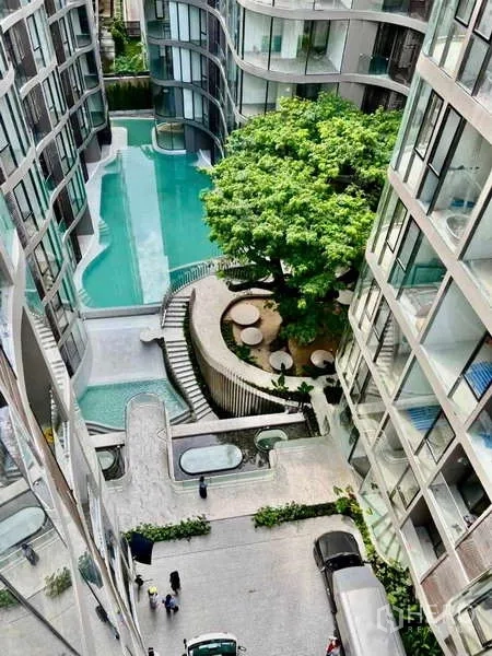 Condominium for rent - Aerial view of the condominium courtyard featuring a curving swimming pool, large tree and terraced walkways.