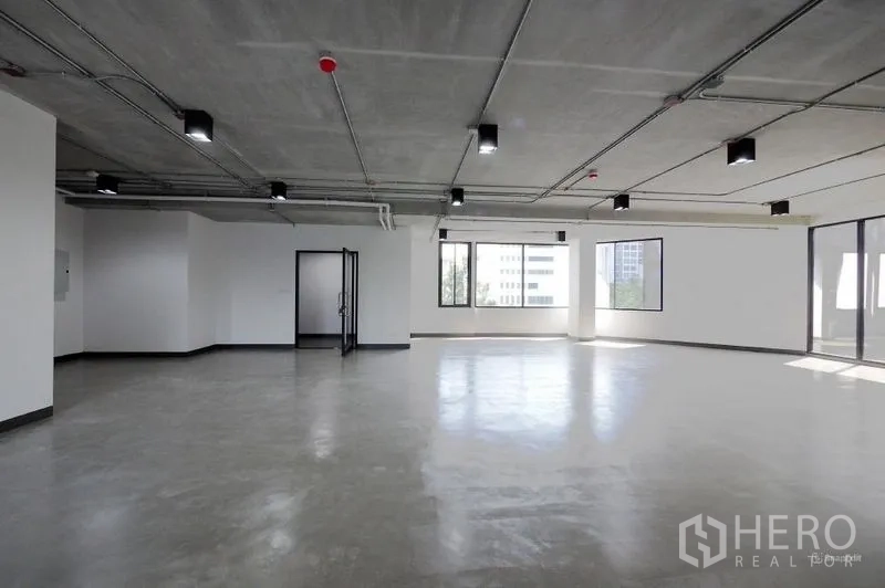 Office Space for rent in Watthana, Bangkok - Large open workspace with multiple windows, industrial ceiling, and polished concrete ready for fit-out.