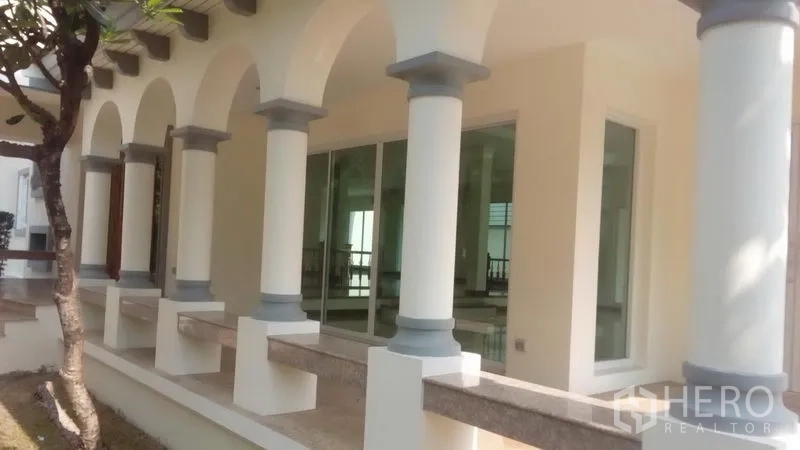 บ้าน ขายในBueng Kum, Bangkok - เฉลียงโค้งพร้อมเสาขาวและประตูกระจกบานเลื่อนของชั้นล่าง