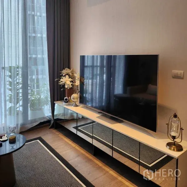 公寓 出租 - 落地窗旁的电视与时尚柜体，配纱帘与遮光帘。