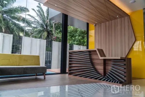 Warehouse for sale in Bang Khen, Bangkok - Stylish lobby with wood reception desk, glass walls and garden view.