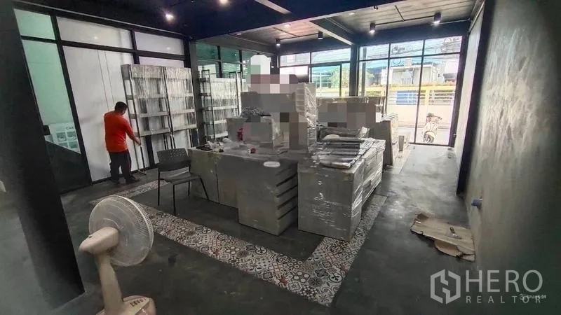 Shophouse for rent in Bang Kho Laem, Bangkok - Bright front room with floor-to-ceiling windows and patterned tile border flooring.