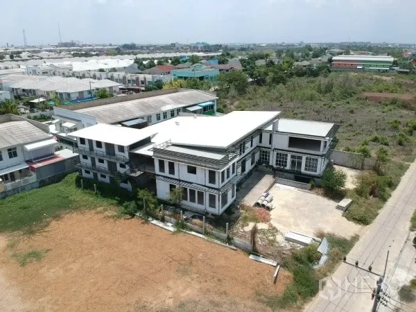 Land for sale in Phra Nakhon Si Ayutthaya, Phra Nakhon Si Ayutthaya - High‑angle shot of the compound with open land, the main structure, and an adjacent side road amid greenery.