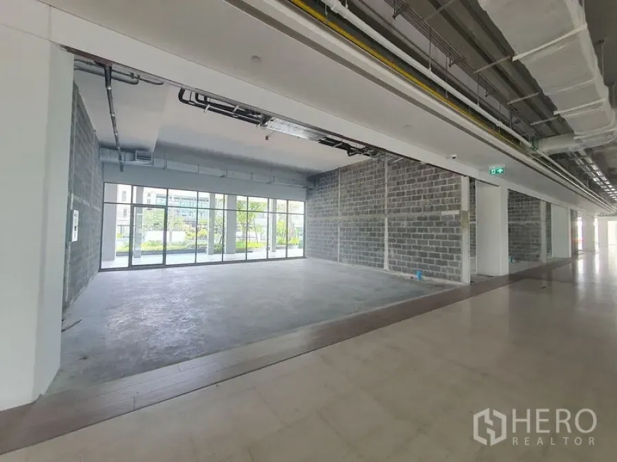 零售空间 出租在Bang Khun Thian, Bangkok - 毛坯零售铺面，混凝土地面，外露天花，整面落地玻璃，面向景观广场。