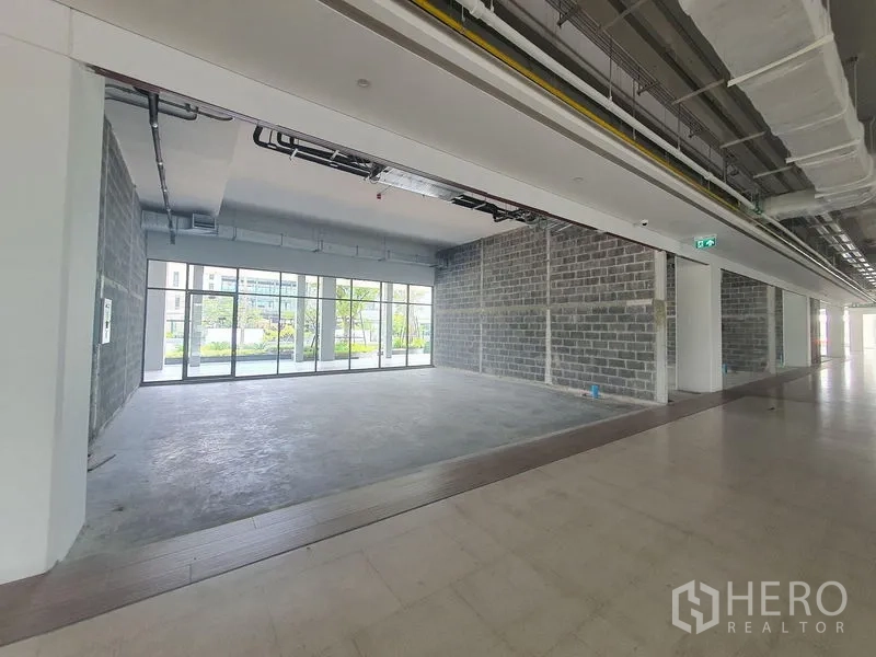 零售空间 出租在Bang Khun Thian, Bangkok - 毛坯零售铺面，混凝土地面，外露天花，整面落地玻璃，面向景观广场。