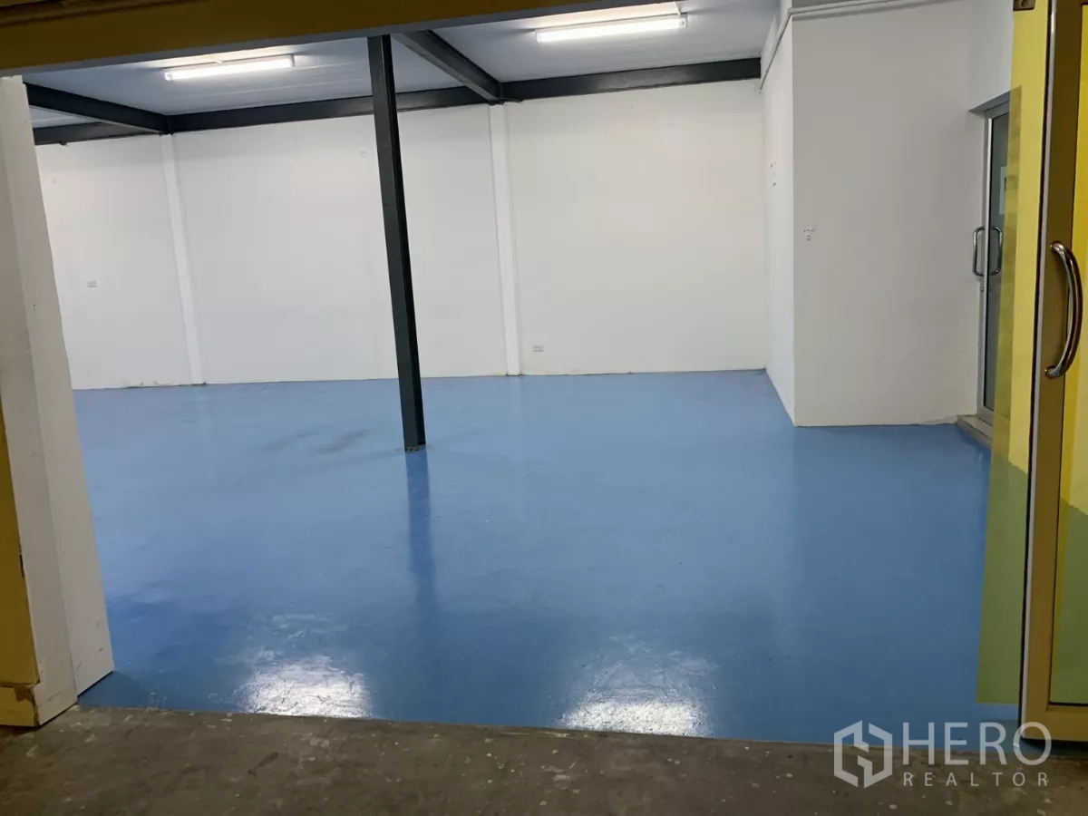 คลังสินค้า ให้เช่าในBang Kapi, Bangkok - ทางเข้าไปยังโซนพื้นอีพ็อกซี่สีน้ำเงิน มีเสาเหล็กและประตูกระจกบานเลื่อน