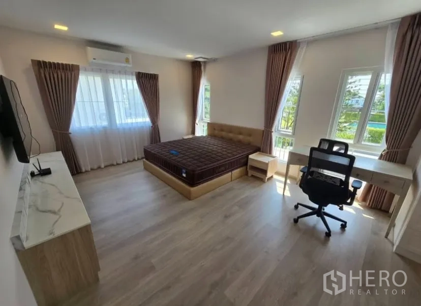 Detached House for rent in Bang Phli, Samut Prakan - Master bedroom corner view showing bed, desk and bright natural light.