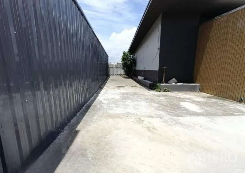 货栈 出租在Prawet, Bangkok - 仓库与办公楼之间的长混凝土通道，通往后方大门，方便卡车进出。