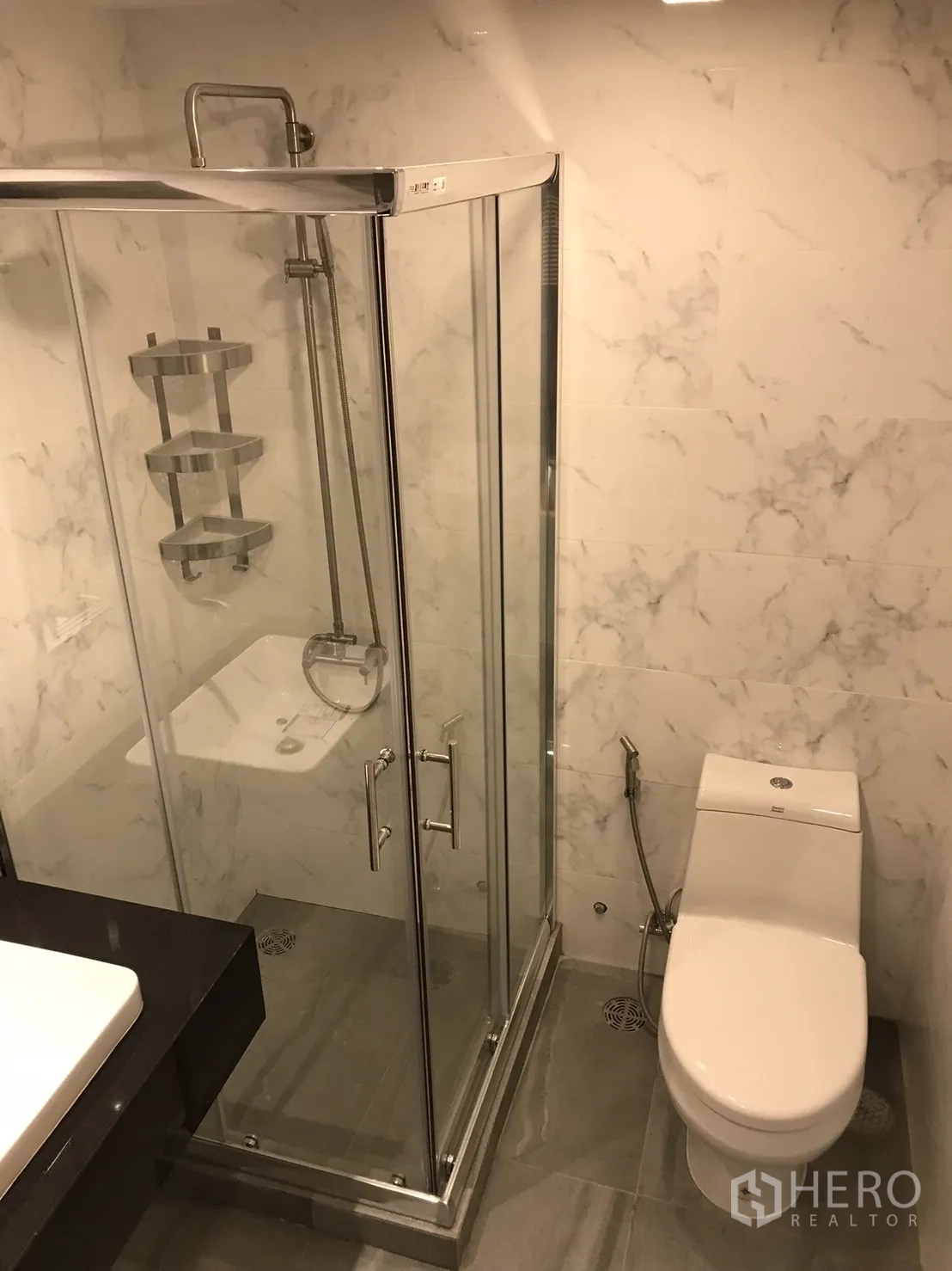 公寓 出租或出售在Khlong Toei, Bangkok - 浴室另一角度，玻璃淋浴房、坐厕与灰色地砖。