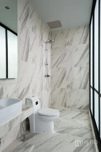 Home Office for rent in Khlong Toei, Bangkok - Bright bathroom with marble-look tiles, walk-in shower and a large window.