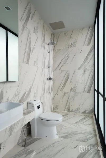 Home Office for rent in Khlong Toei, Bangkok - Bright bathroom with marble-look tiles, walk-in shower and a large window.