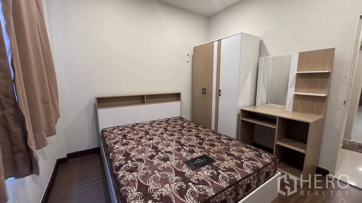 บ้าน ให้เช่าหรือขายในSaphan Sung, Bangkok - ห้องนอนขนาดกะทัดรัด มีเตียง ตู้เสื้อผ้า และโต๊ะเครื่องแป้ง โทนสีอบอุ่นพื้นไม้.