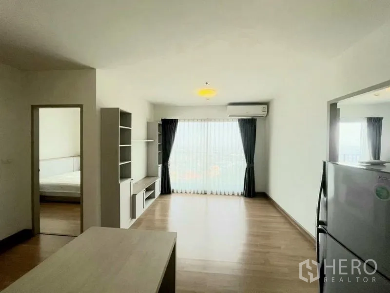 Condominium for sale - Spacious living room with floor-to-ceiling window, sheer drapes and air conditioner.