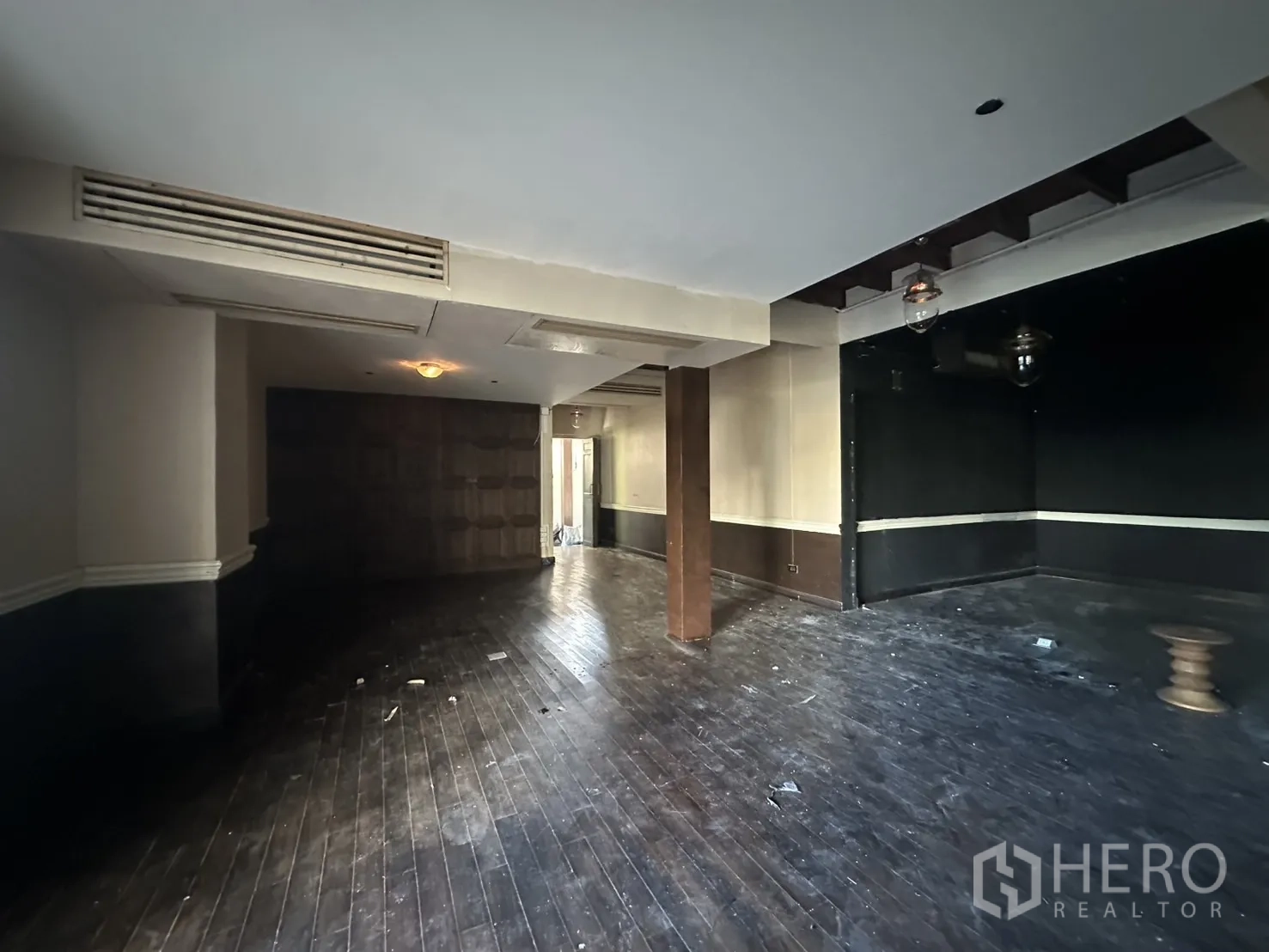 Detached House for rent - Corner room with timber flooring, a column and black feature wall.