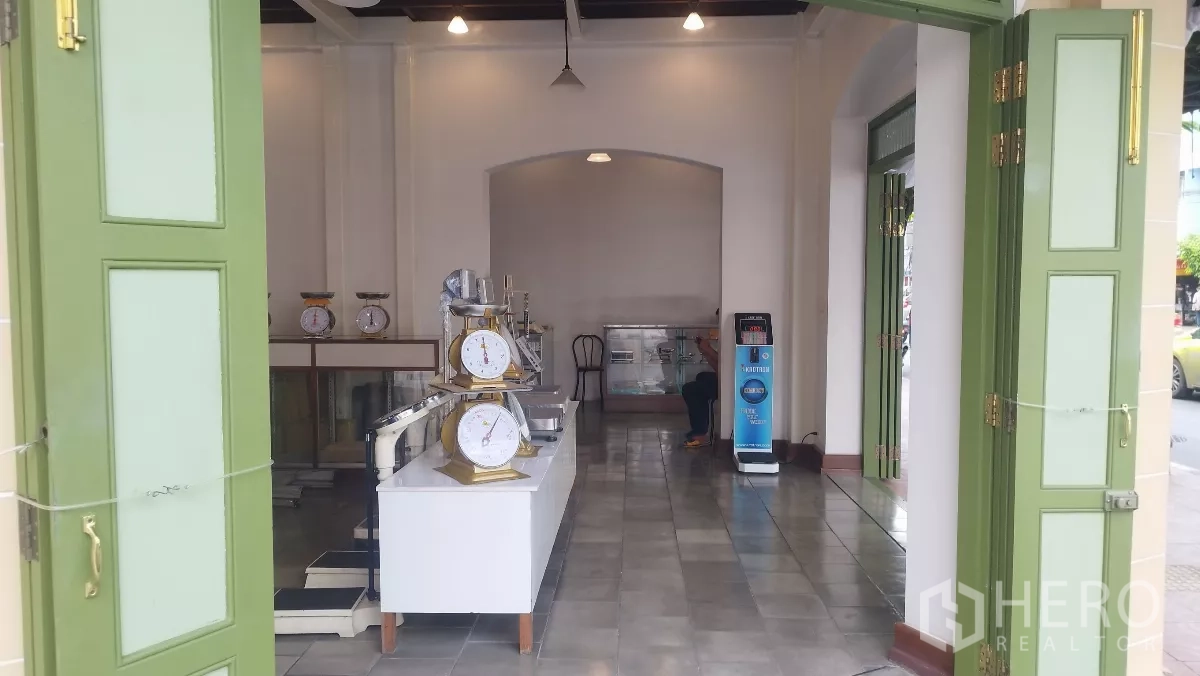 零售空间 出租在Bangkok - 绿色折叠大门敞开，采光充足的店内与地砖地面。