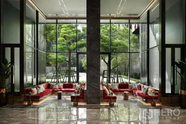 คอนโด ขายในRatchathewi, Bangkok - ล็อบบี้เพดานสูง โซฟาสีแดง กระจกเต็มบานมองเห็นต้นไม้เขียว